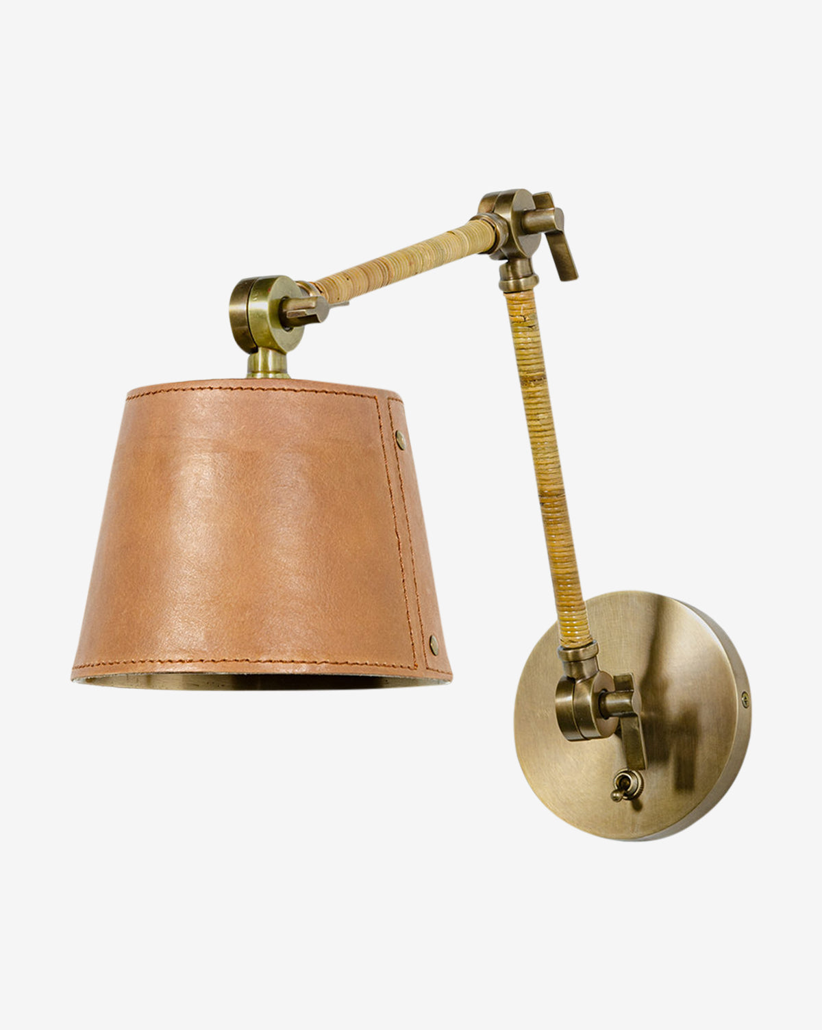 The Palecek Hendrick Articulating Sconce features a brass frame with an adjustable neck and a light brown leather shade, displayed against a plain white background. Vendixs