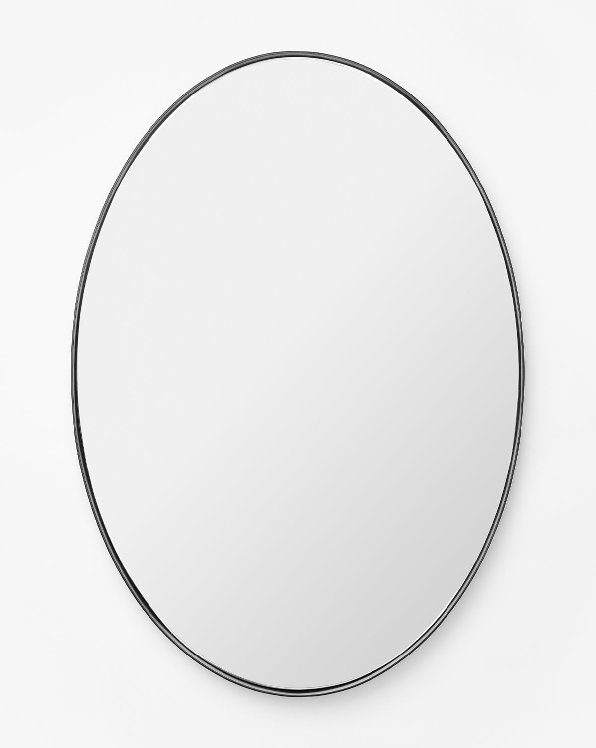 The Hogan Oval Mirror features a sleek stainless steel frame and is mounted on a plain white wall, reflecting a blank surface, by Vendixs