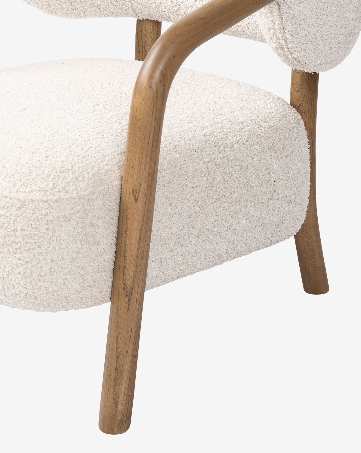Close-up of the Holstein Lounge Chair featuring a curved solid oak frame and armrest, upholstered in textured faux Mongolian shearling. The design emphasizes the contrast between smooth wood and soft fabric, by Vendixs