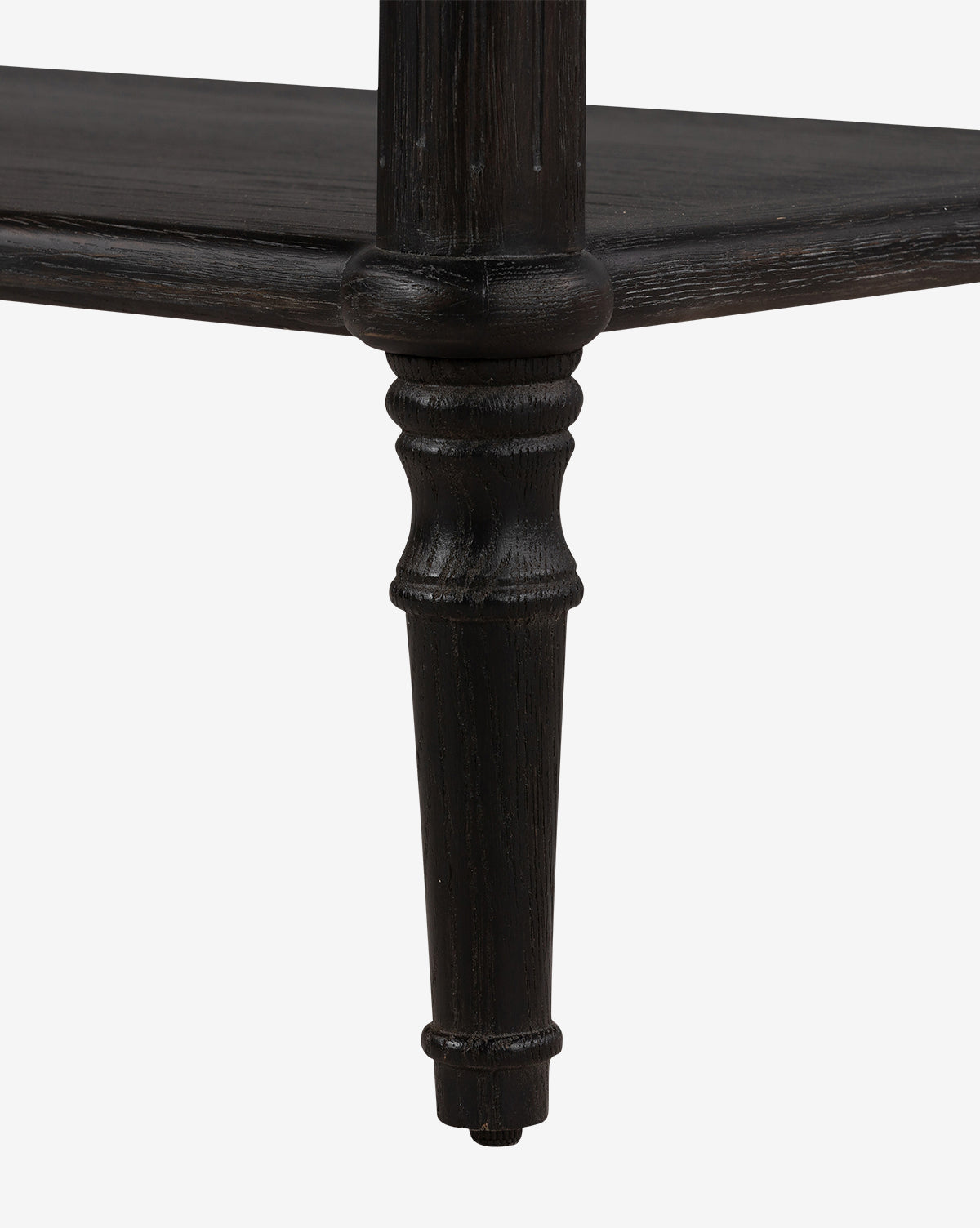 Close-up of the Humphrey Nightstand’s dark wooden leg with carved details and a lower shelf, set against a white background—highlighting the timeless elegance of this traditional bedroom furniture piece, by McGee & Co.