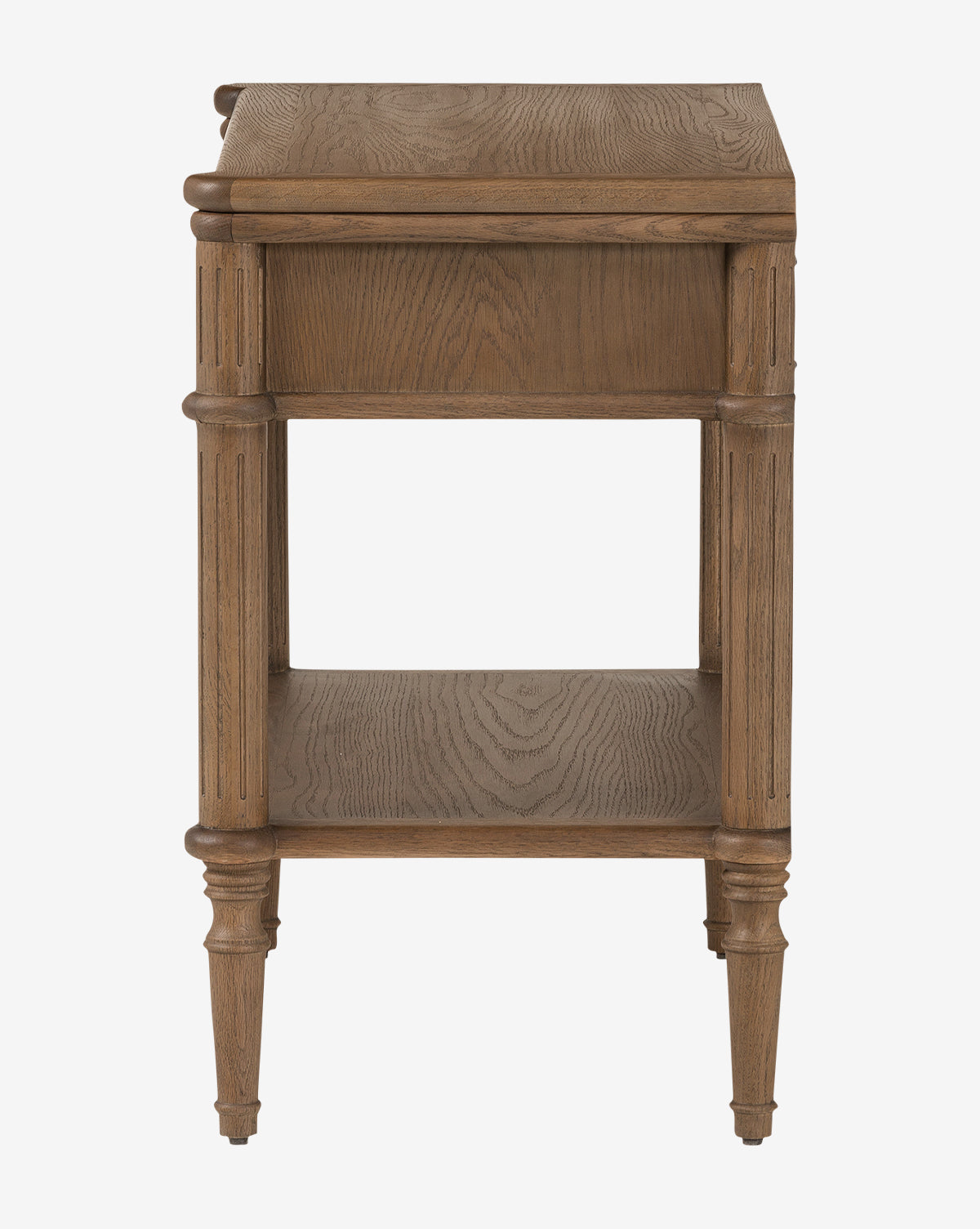 The Humphrey Nightstand is a wooden piece with fluted legs, a natural finish, one lower shelf, and a rectangular top featuring subtle carved edges—an elegant traditional design shown from the side by McGee & Co.