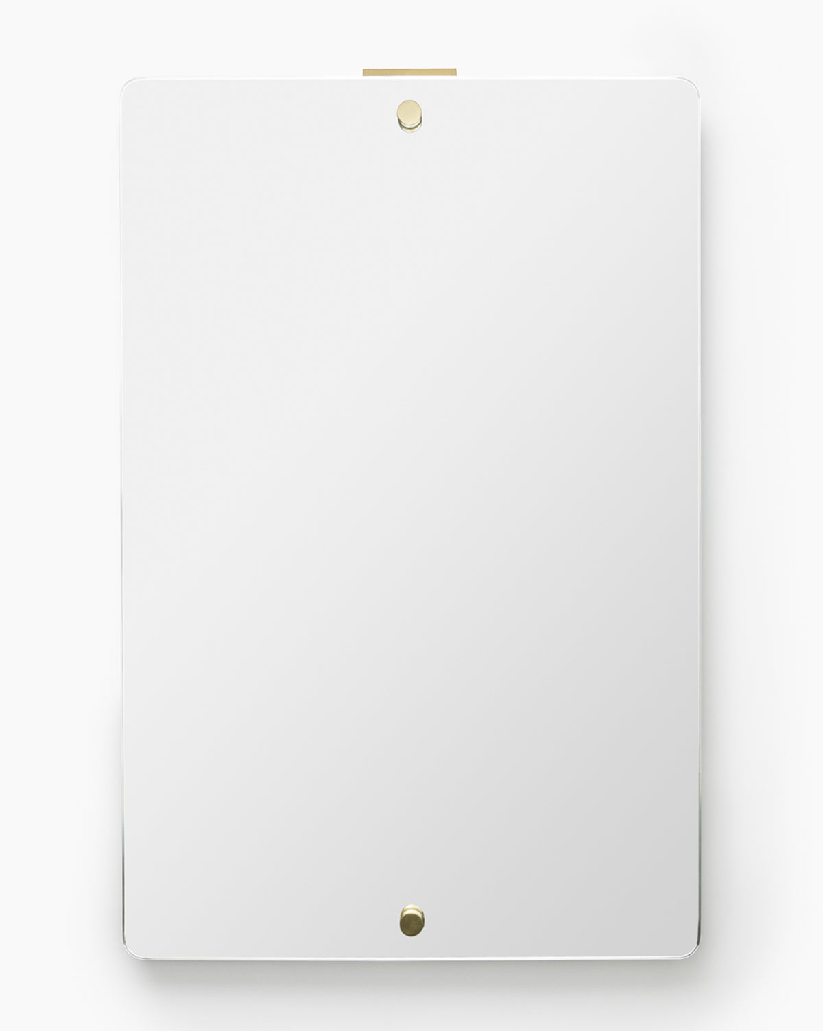 The Jacob Rectangular Mirror, featuring a frameless design with rounded corners, is mounted vertically on a white wall and secured by two small, round, gold-colored fasteners at the top and bottom, by Vendixs