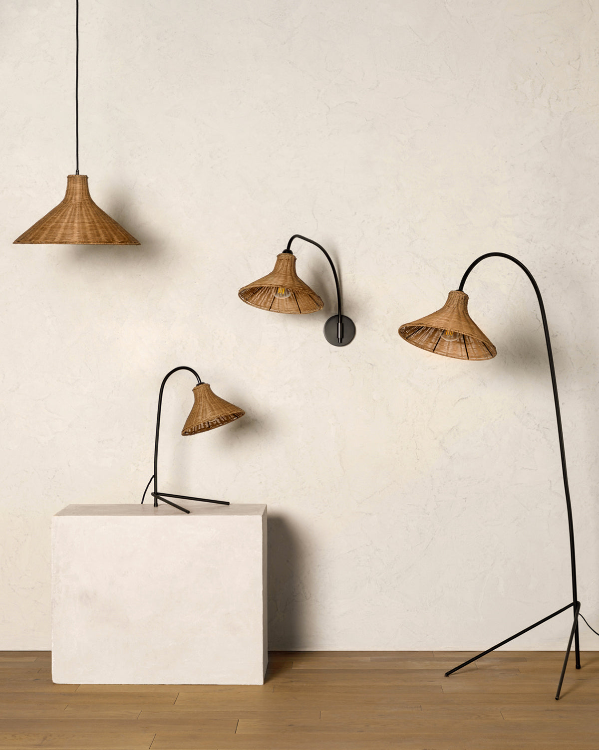 Four Johanson Woven Floor Lamps with black metal stands are showcased: a pendant lamp hangs from the ceiling, a wall lamp is mounted, and two Johanson Woven Floor Lamps of varying heights stand beside a white block on a wooden floor, by Vendixs