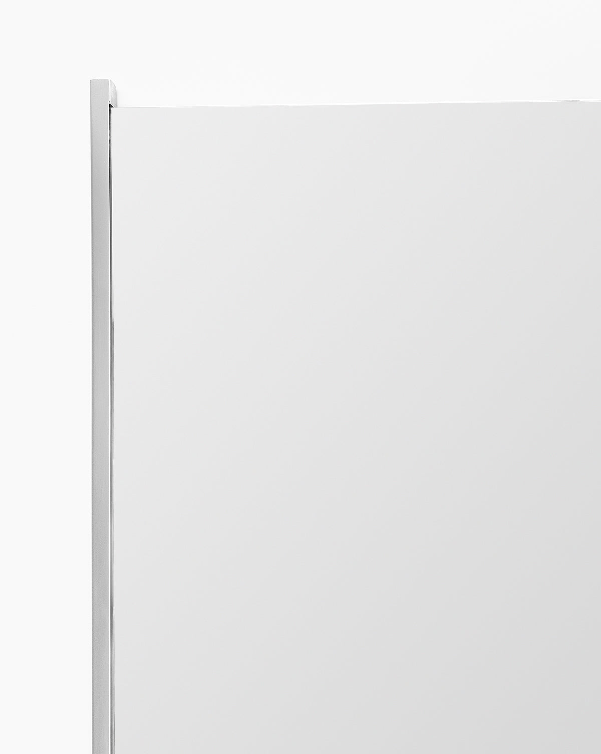 A close-up of the top corner of the Julie Mirror, a rectangular bathroom mirror with a thin polished nickel frame, set against a plain white background, by Vendixs