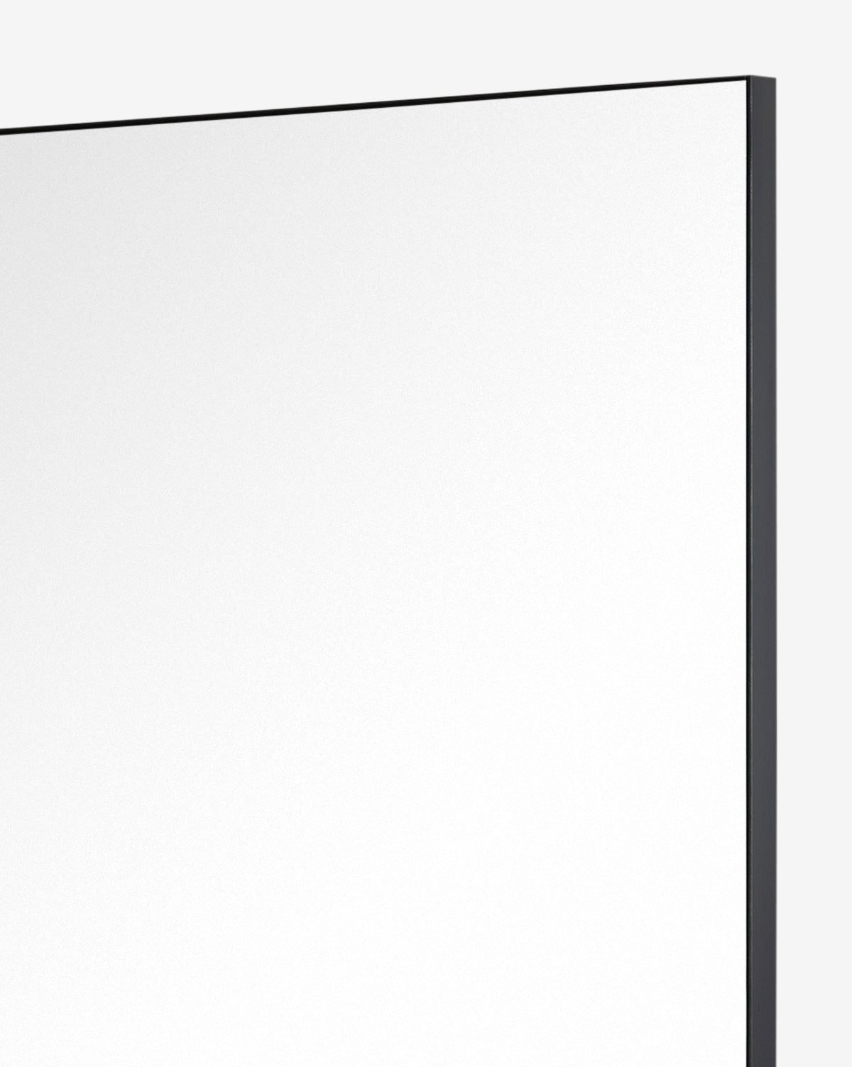 A close-up of the top right corner of the Knowles Mirror, featuring a slim Black Nickel frame against a plain light background, by Vendixs