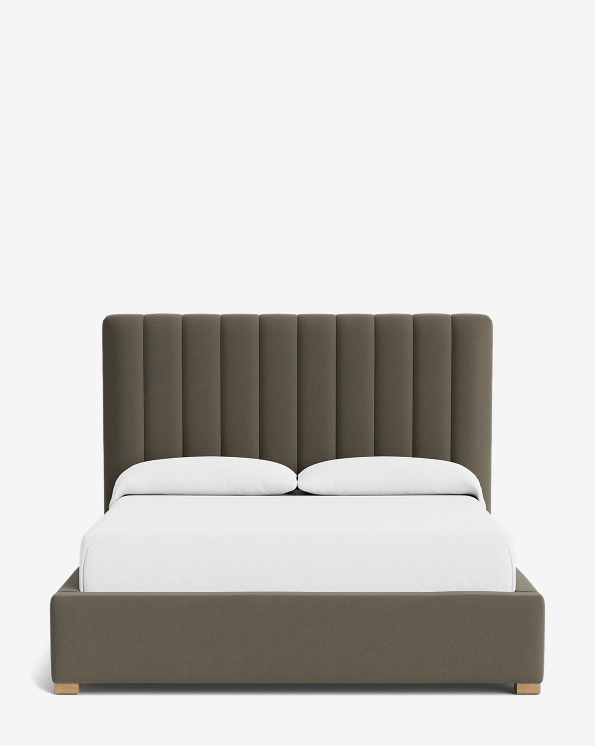 The Hoffman Bed Tall Headboard features a tall, vertical channeled design in dark olive green, shown with white bedding and two pillows. Customize your look with a variety of fabric options for a modern touch by McGee & Co.