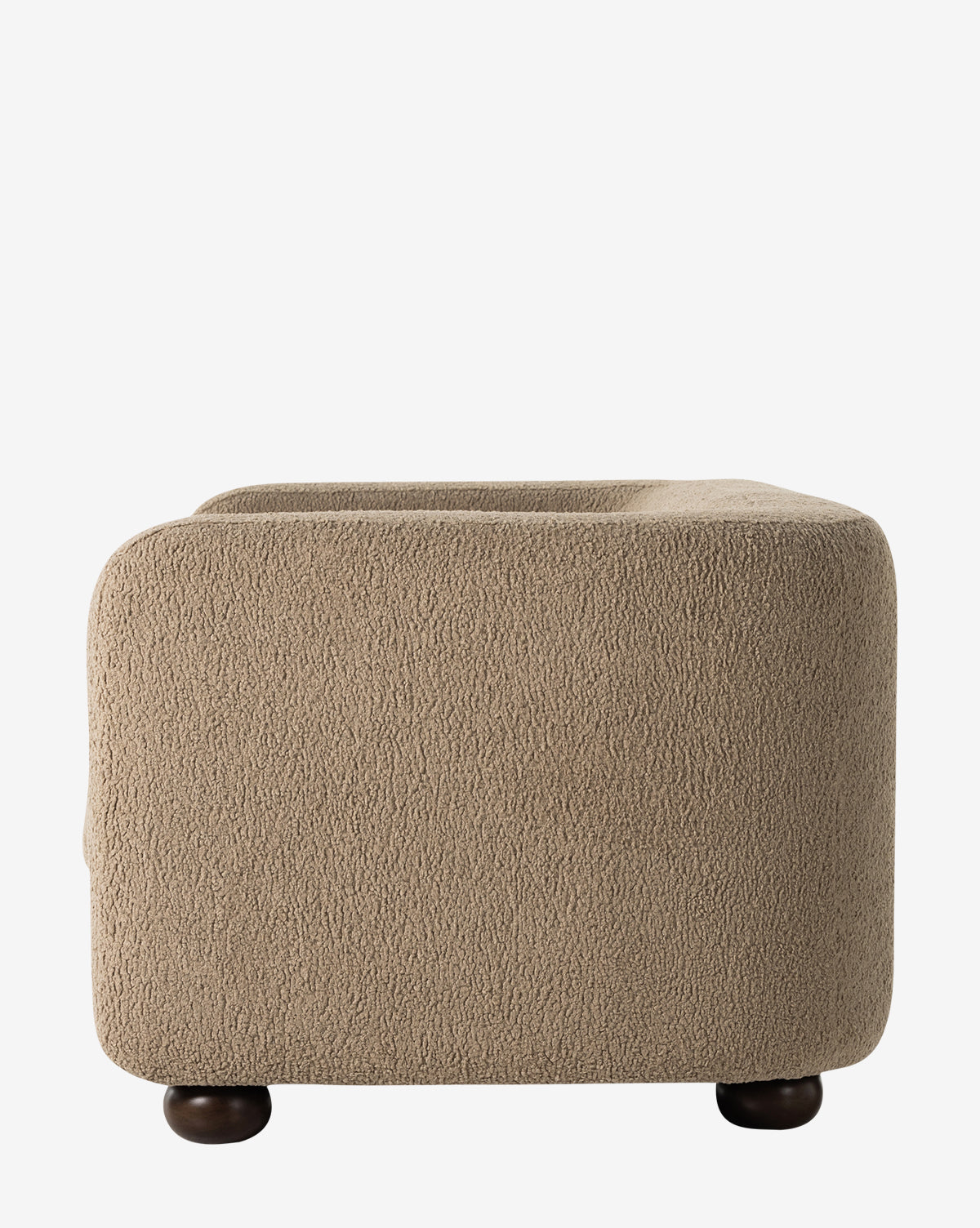 The Four Hands Quill Sofa 84 features a beige, textured finish with rounded edges and dark circular wooden feet, evoking vintage charm. Shown from the side against a plain white background. Vendixs