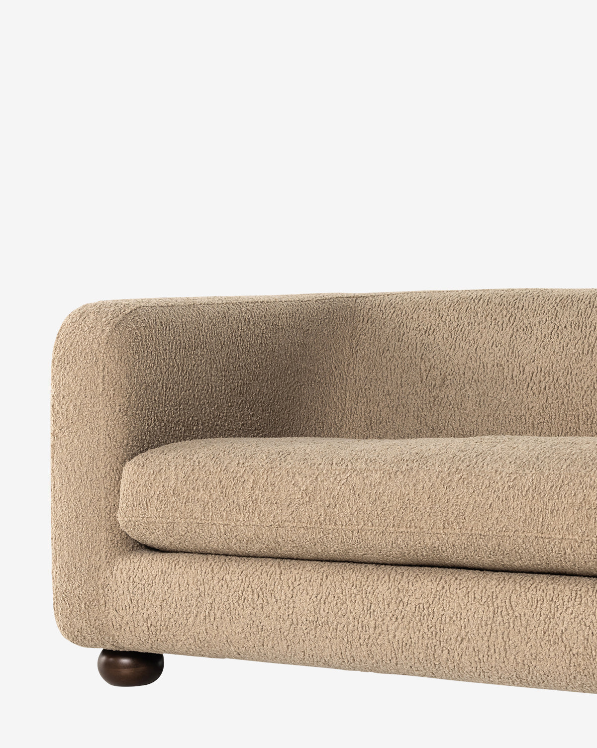 A close-up of the Four Hands Quill Sofa 84 in modern beige faux shearling, featuring textured upholstery, rounded armrest, and a visible dark wooden leg, set against a plain white background. Vendixs