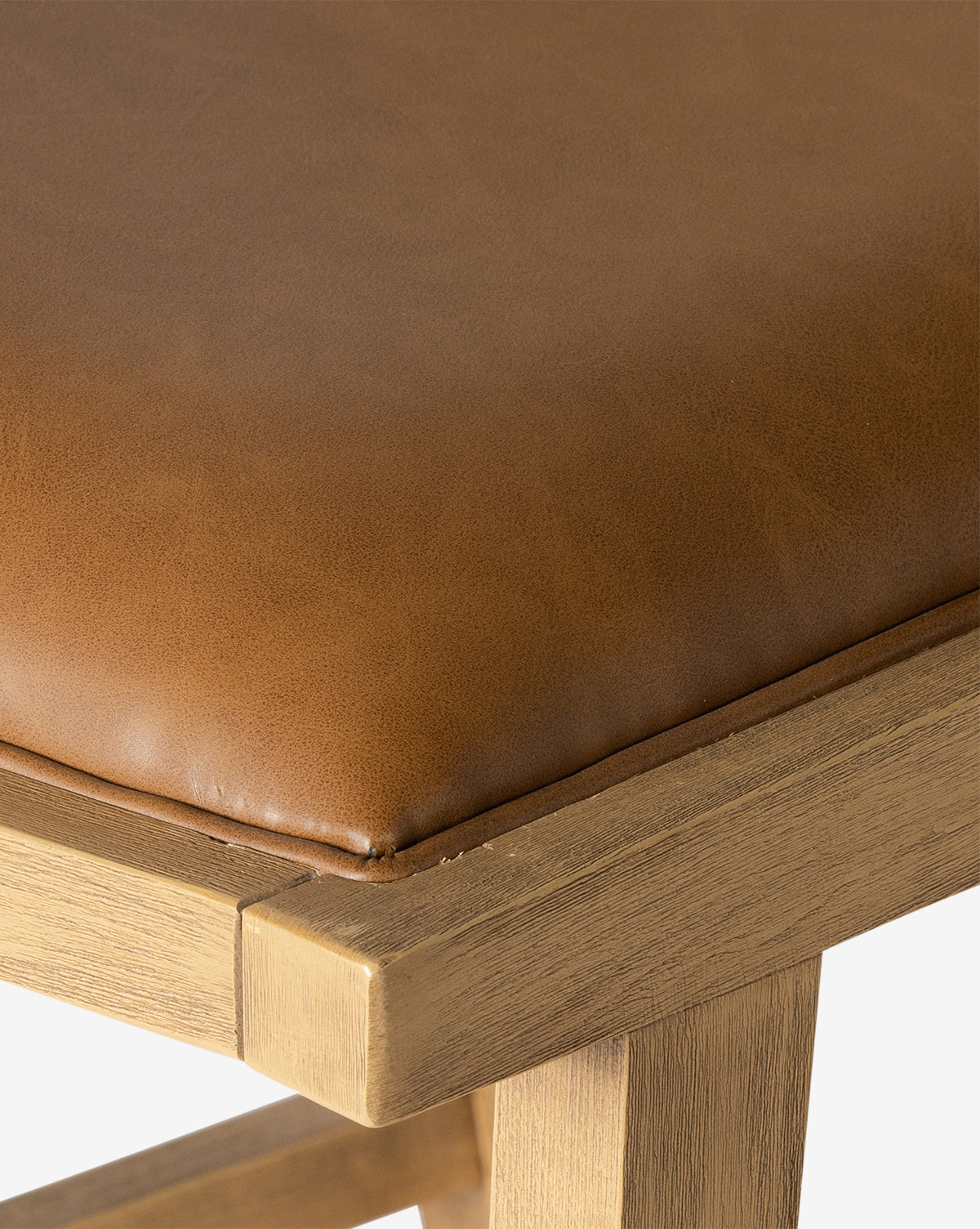Close-up of the Emeline Stool, showcasing its solid beech frame and light brown faux leather cushion. The image emphasizes the cushion’s texture and the wood’s smooth finish, by Vendixs