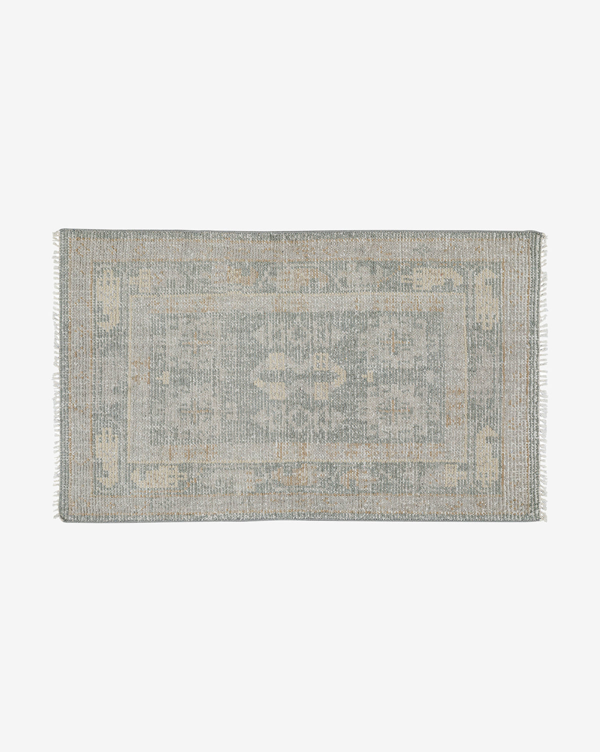 The Roslin Hand-Knotted Wool Rug is a rectangular, vintage-style wool rug with a faded floral pattern in muted blue and beige tones, finished with short fringe on the shorter edges, by Vendixs