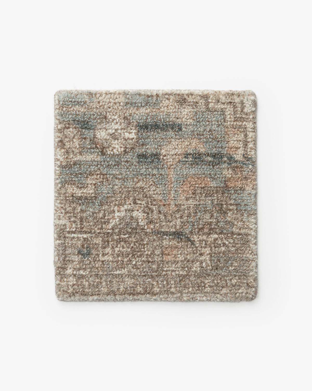 The Wilshire Blue Rug Swatch is a square, hand-tufted wool sample with a textured surface in muted brown, beige, blue, and peach hues. It features an abstract design and is shown on a plain white background by Vendixs