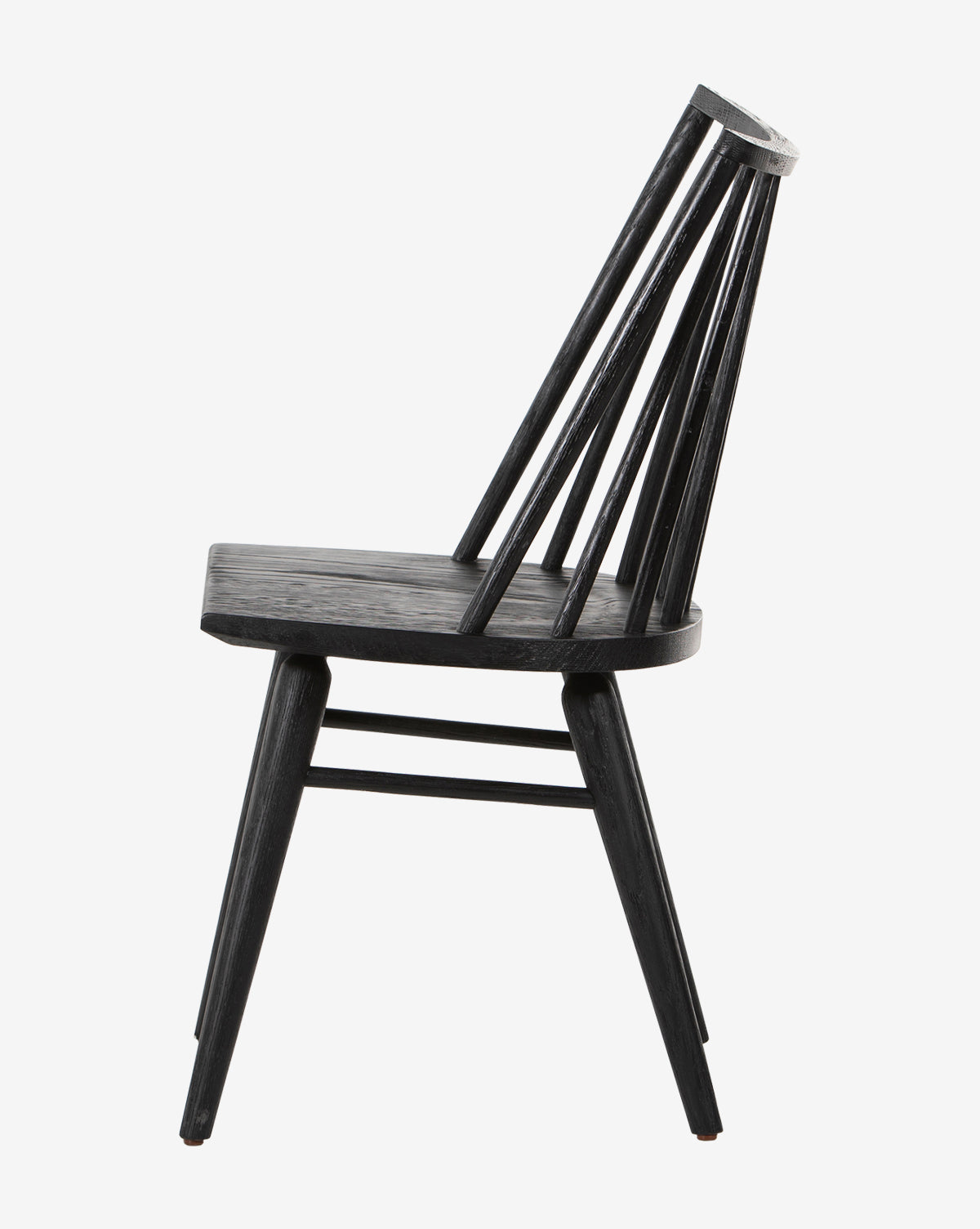 The Madison Dining Chair is shown in profile against a white background. It features a black finish, flat seat, angled legs, and a curved backrest with vertical spindles by McGee & Co.