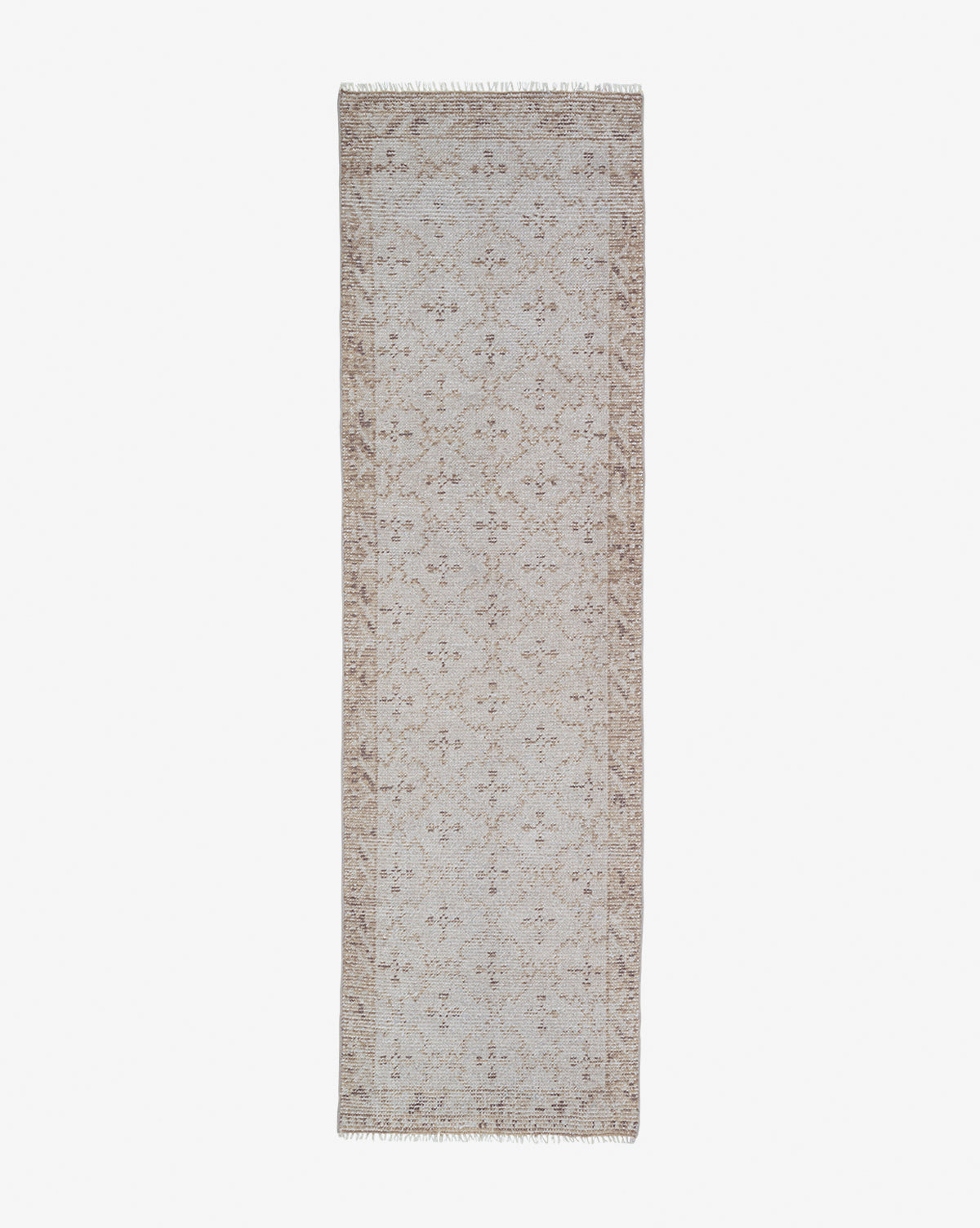 The Mali Hand-Knotted Rug is a rectangular, beige rug with an intricate floral pattern and fringed edges, shown on a white background—a versatile neutral accent for any room, by Vendixs