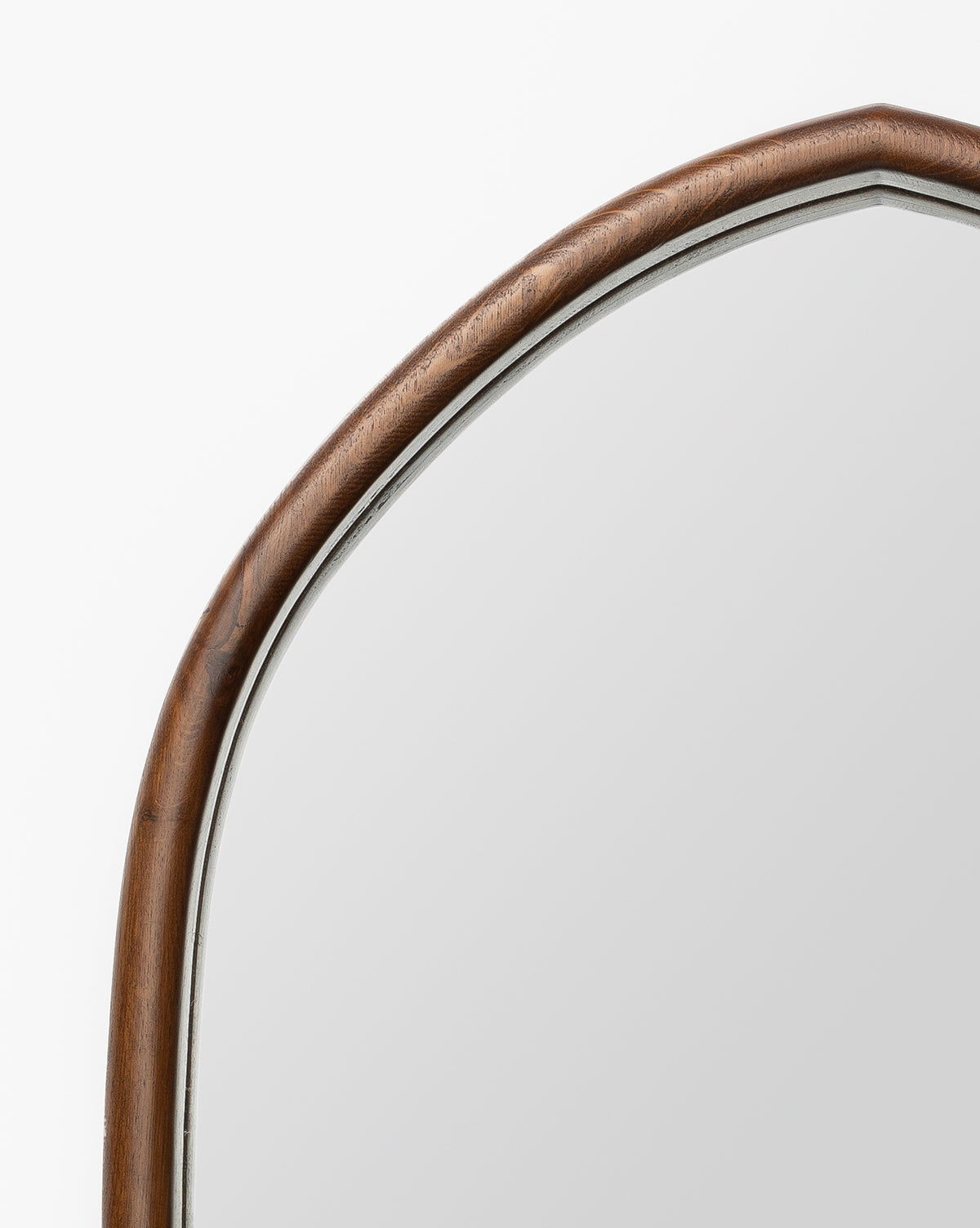 A close-up of the Oslo Mirror showcases its oak frame with a smooth brown finish and gentle curves, set against a plain white background, by Vendixs