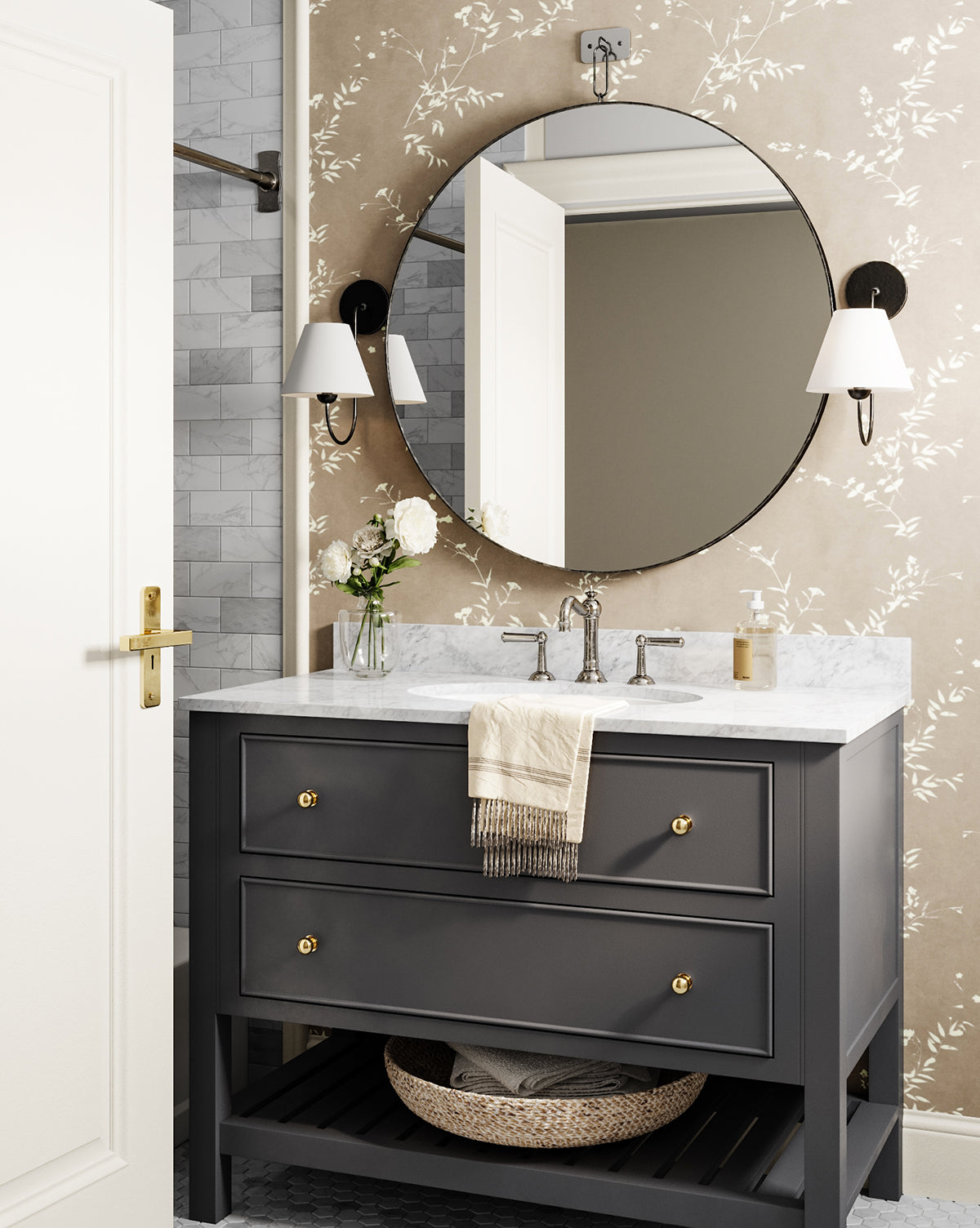 A modern bathroom vanity with a marble countertop, gray drawers with gold knobs, the Haven Wall Mirror, two wall sconces, a towel, and a vase of white flowers. The wallpaper has a subtle floral pattern by Vendixs