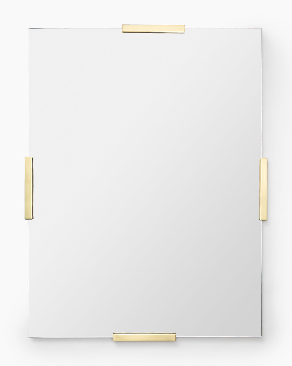 The Slade Mirror is a rectangular frameless mirror secured by four gold metal brackets on each side, creating a sleek modern look against a plain white background, by Vendixs