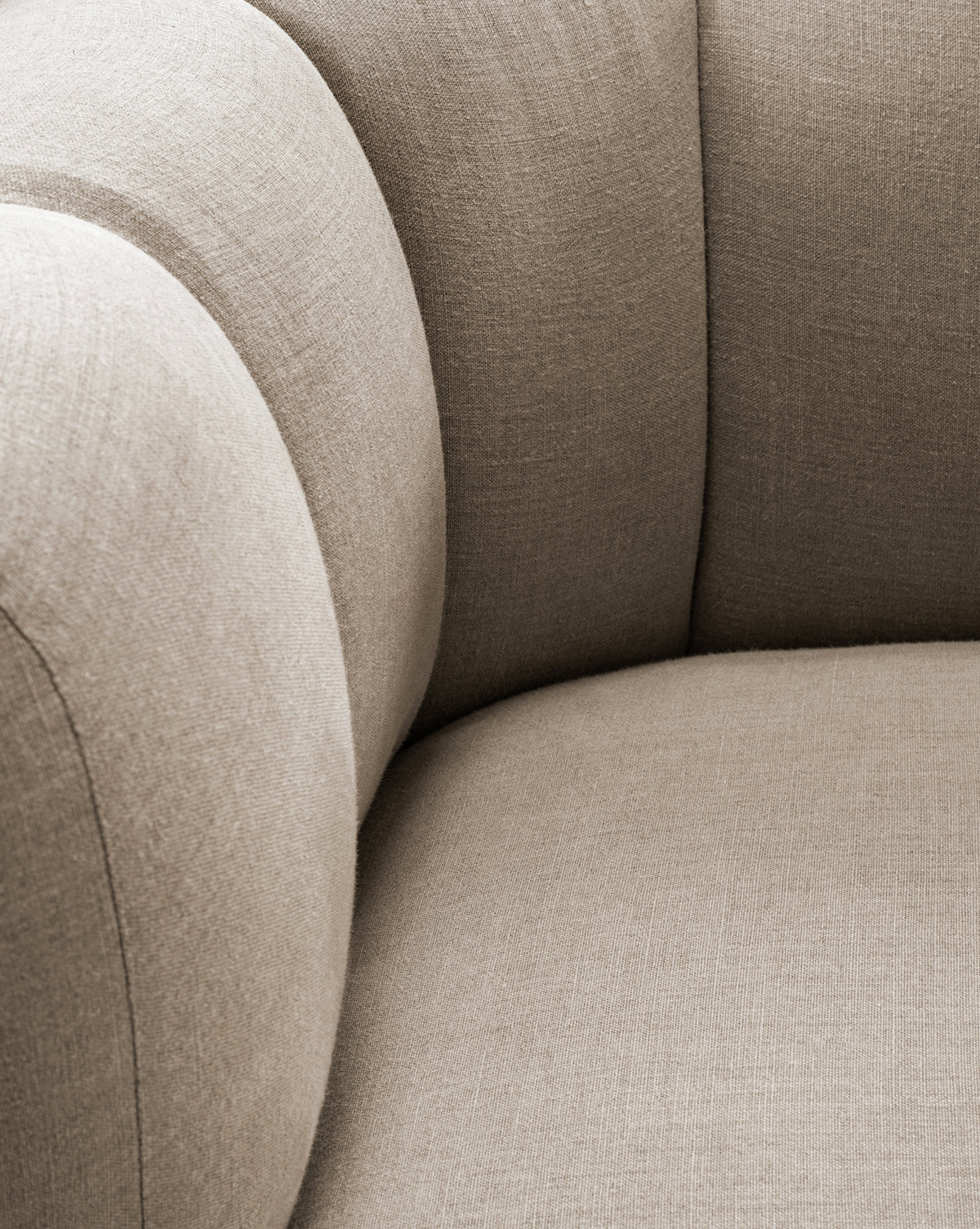Close-up of the Ines Lounge Chair, featuring a curved backrest and seat upholstered in soft, textured fabric. Its comfortable design emphasizes modern, contemporary style, by McGee & Co.