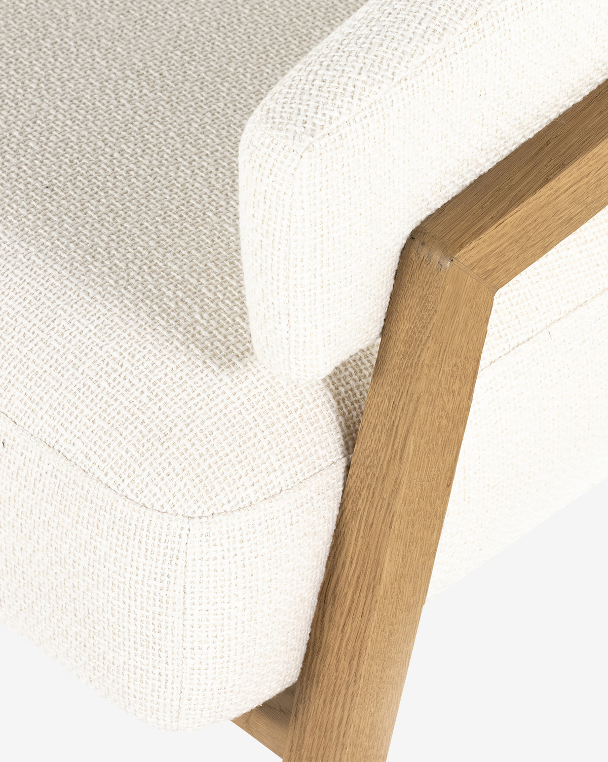 Close-up of the Stanley Lounge Chair, featuring a contemporary design with a textured off-white cushion and light wood frame, focusing on the armrest and seat against a plain background, by Vendixs