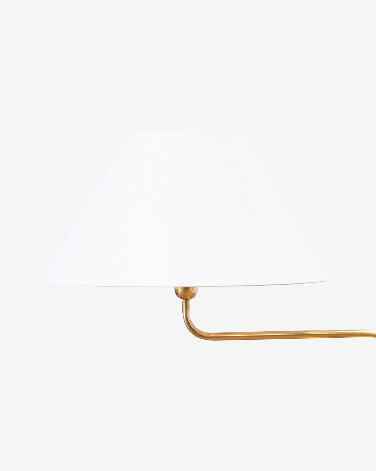 The Wainwright Swoop Floor Lamp features a white cone-shaped shade and a brass arm extending right, shown against a plain white background, by Vendixs