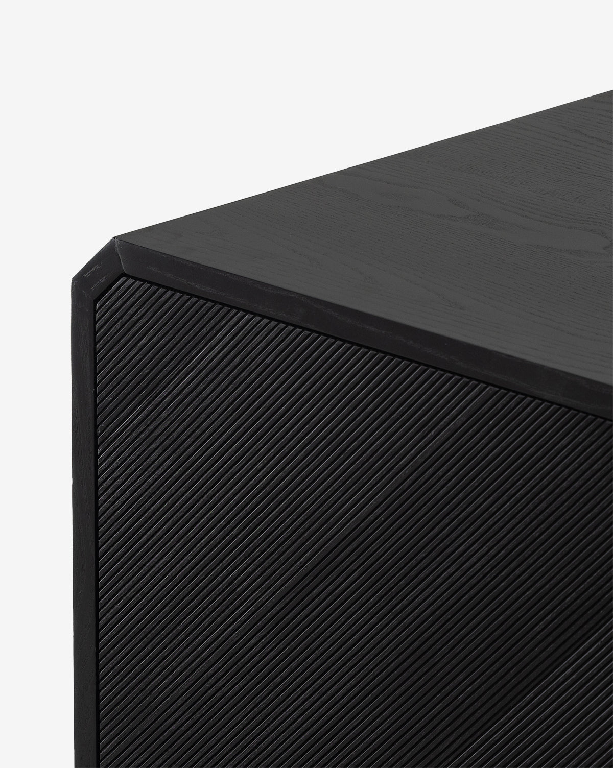 Close-up of the Ziggy Sideboards corner, showcasing its modern black ash veneer with textured diagonal lines on the front panel and a smooth top—ideal as a sleek storage solution, by McGee & Co.