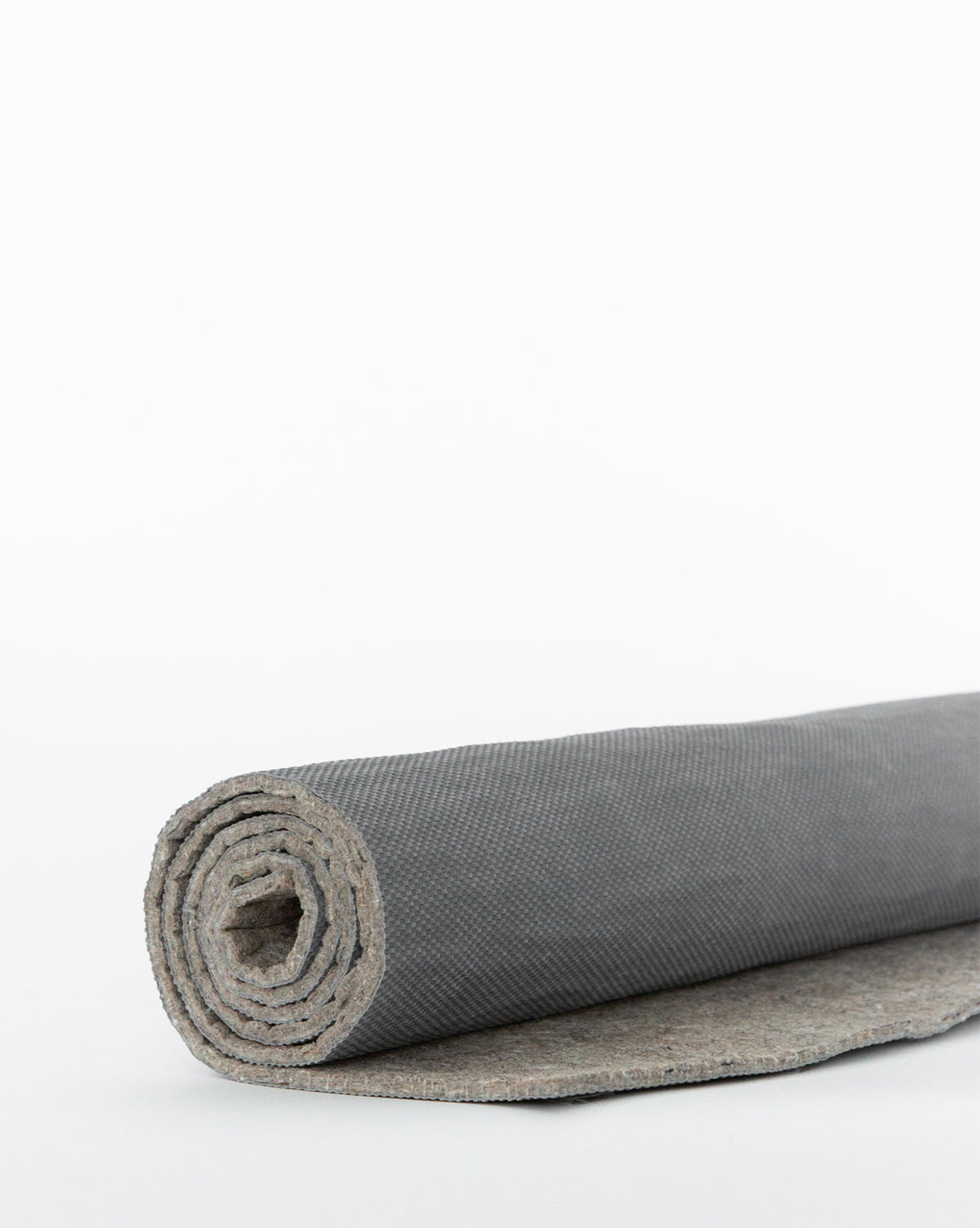 The Premium Indoor Rug Pad, shown partially unrolled on a plain white background, features a textured gray surface and built-in no-slip grip for secure, comfortable use, by Vendixs